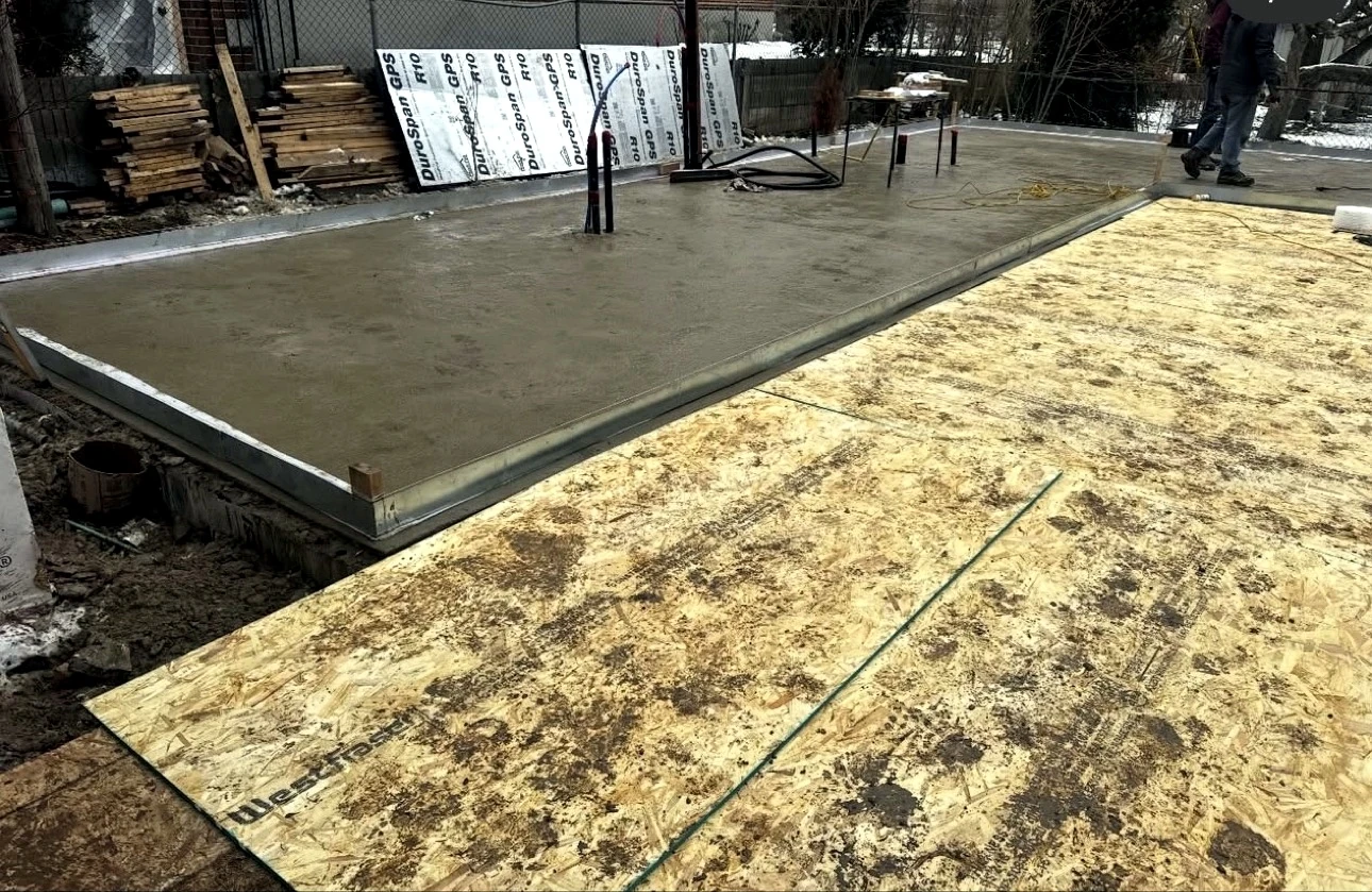 Real Pisces jobsite: garden suite foundation slab with insulation boards and plumbing rough-in, winter