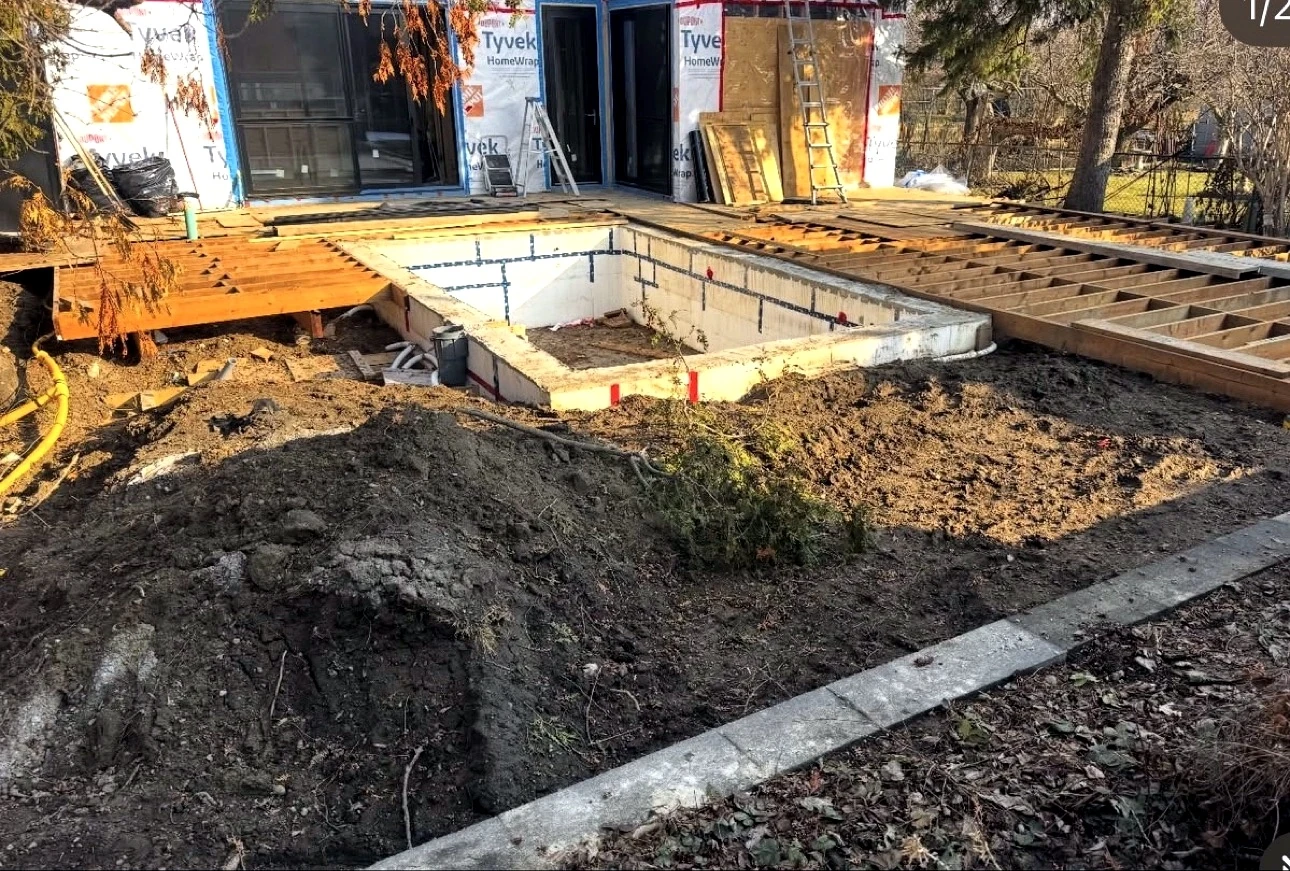 Real Pisces jobsite: block pool shell and earthworks with the house weather-wrapped