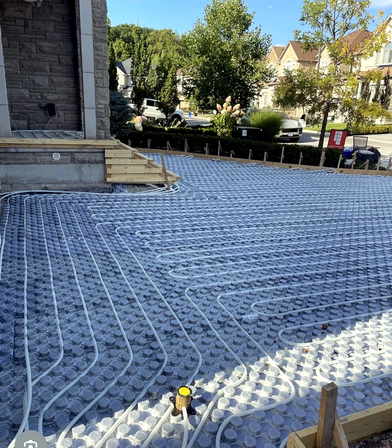 Real Pisces work — hydronic snow-melting pipe installation across a residential driveway