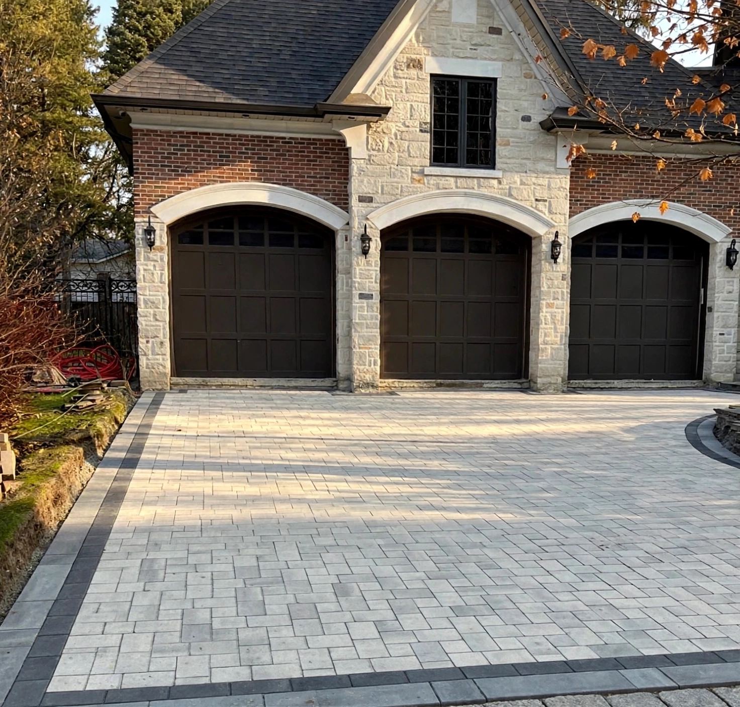 Design concept — finished heated driveway visualization with light-grey interlock pavers and charcoal border accents